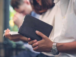 praying while holding a bible