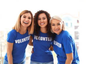 group of 3 volunteer smiling